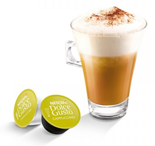 Cappuccino dans un grand verre avec deux dosettes de cappuccino Dolce Gusto. Garniture de mousse saupoudrée de cacao.