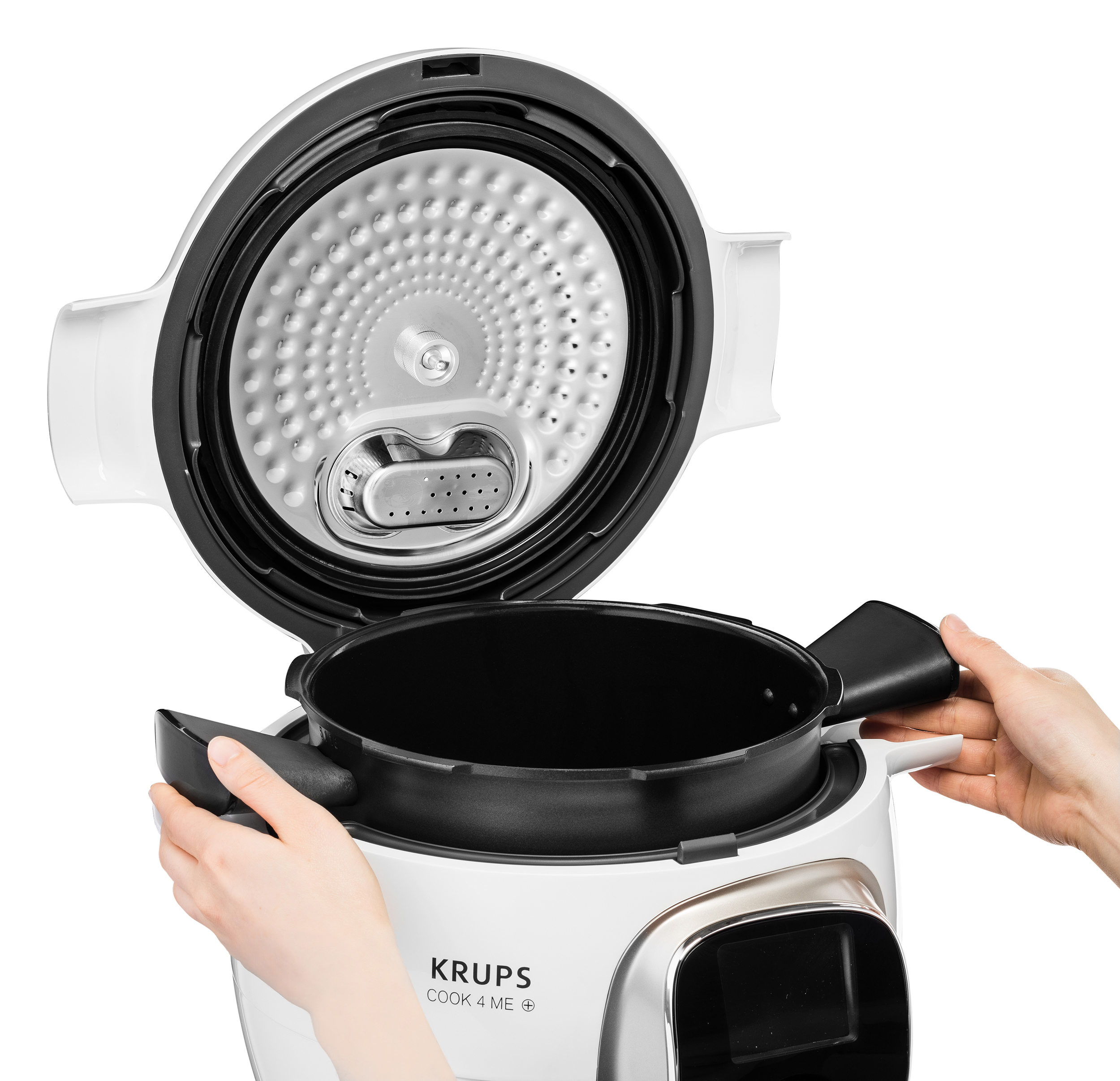 Ein weißer und schwarzer Krups Cook 4 Me Multikocher, geöffnet, mit Händen, die den Innentopf halten.