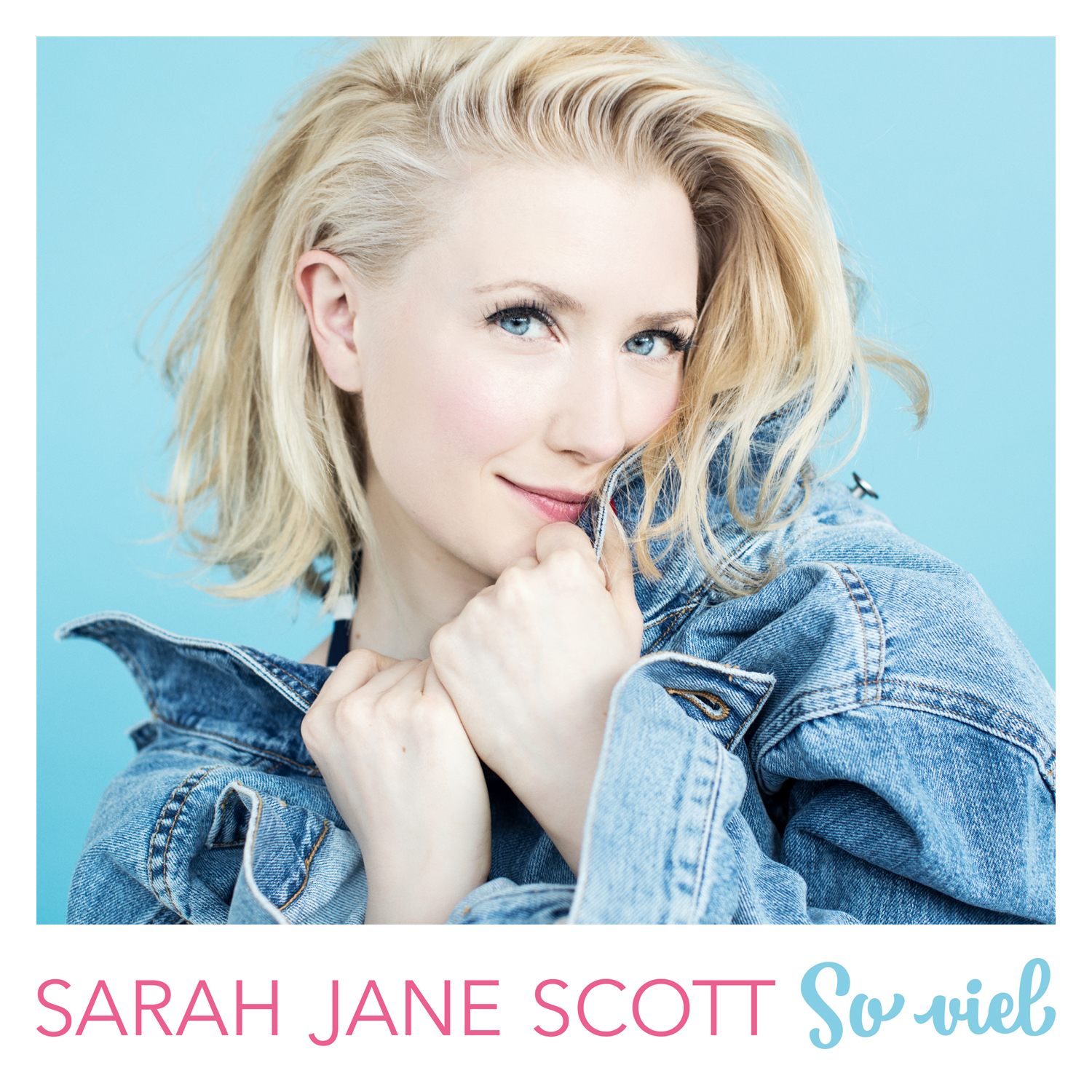 Eine blonde Frau in einer Jeansjacke lächelt. Text: Sarah Jane Scott, So viel.