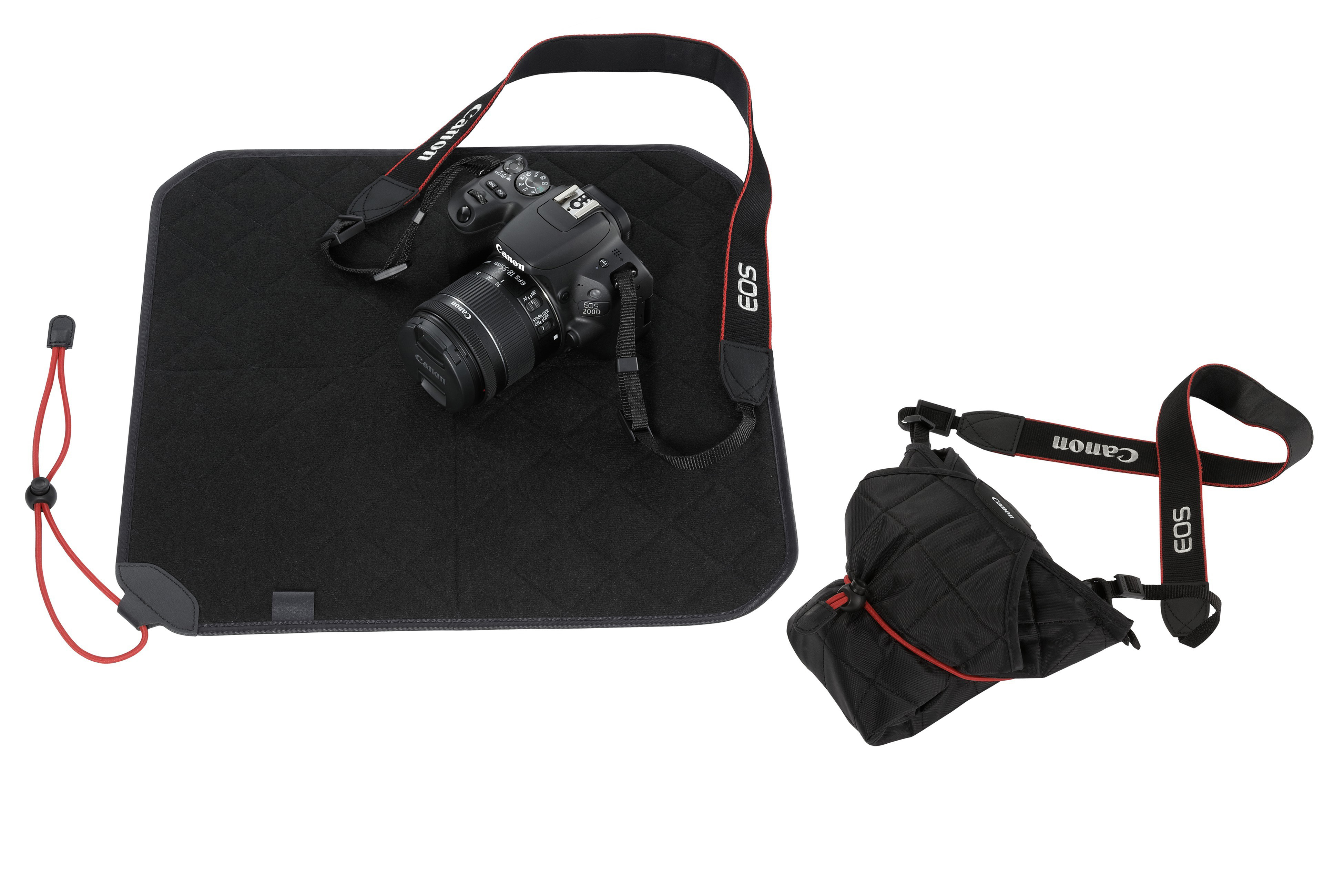 Eine schwarze Canon-Kamera mit Gurt liegt auf einer quadratischen Matte und ist daneben auch als Tasche eingepackt zu sehen.