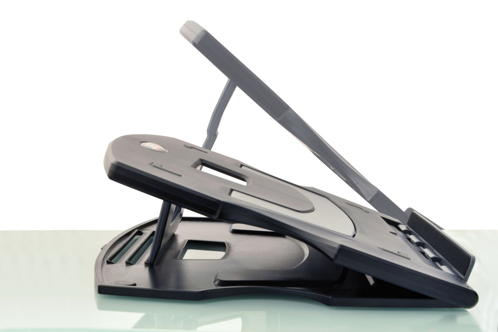 Black laptop stand, angled. Grey surface and white background. Adjustable.