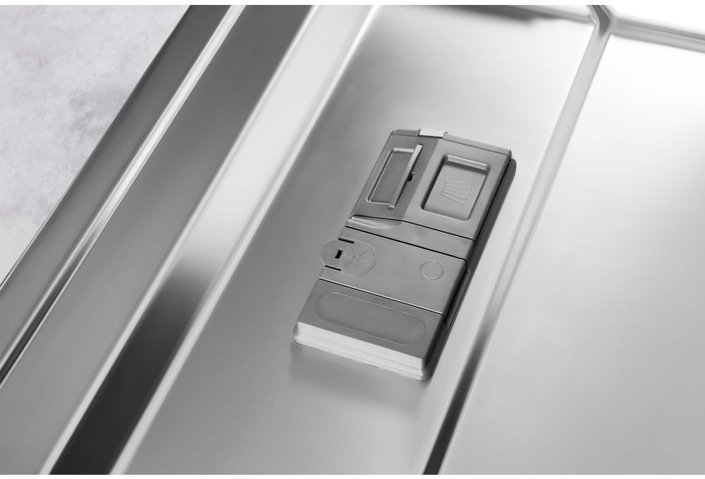 Distributeur de savon pour lave-vaisselle, couleur argent, à l'intérieur d'un lave-vaisselle.