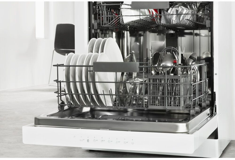 Lave-vaisselle ouvert, rempli de vaisselle, d'ustensiles et un intérieur blanc.