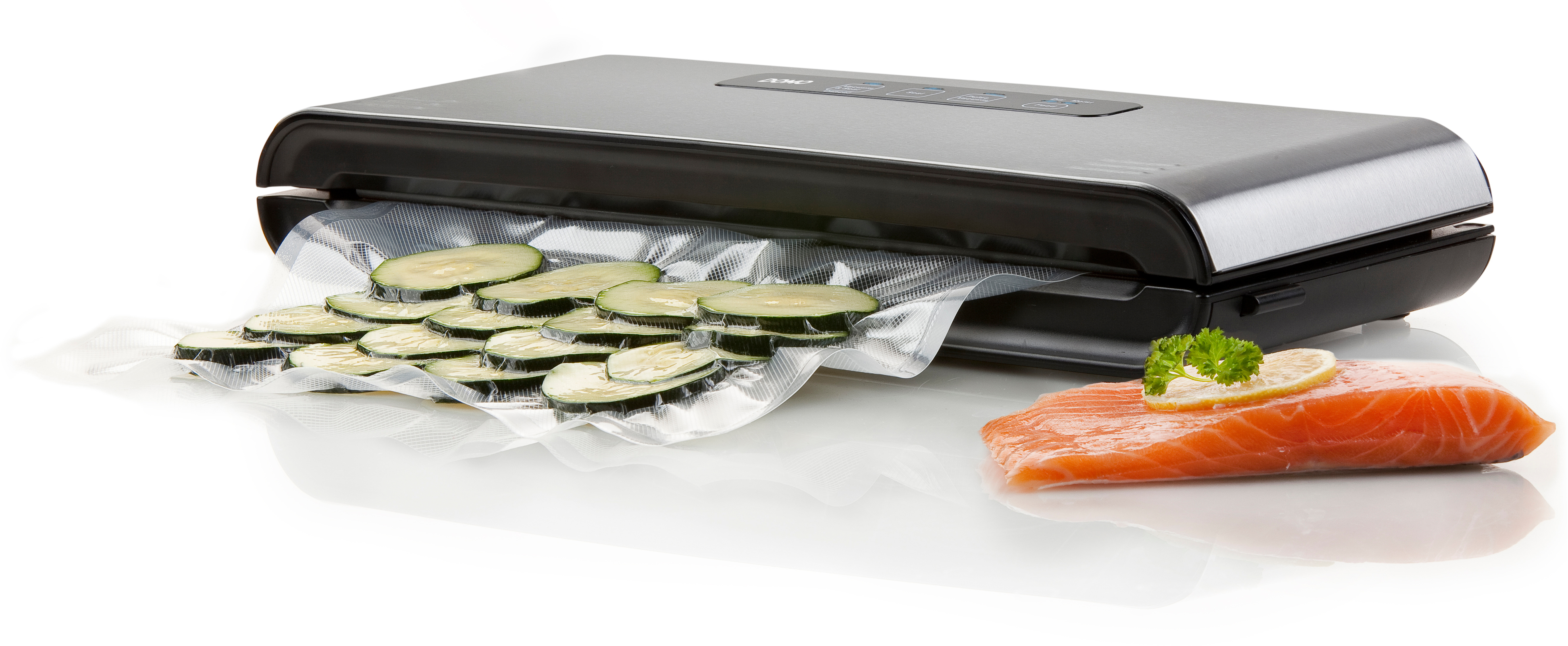 Scelleuse sous vide avec tranches de courgettes et saumon sur une surface blanche. Machine noire et argentée.