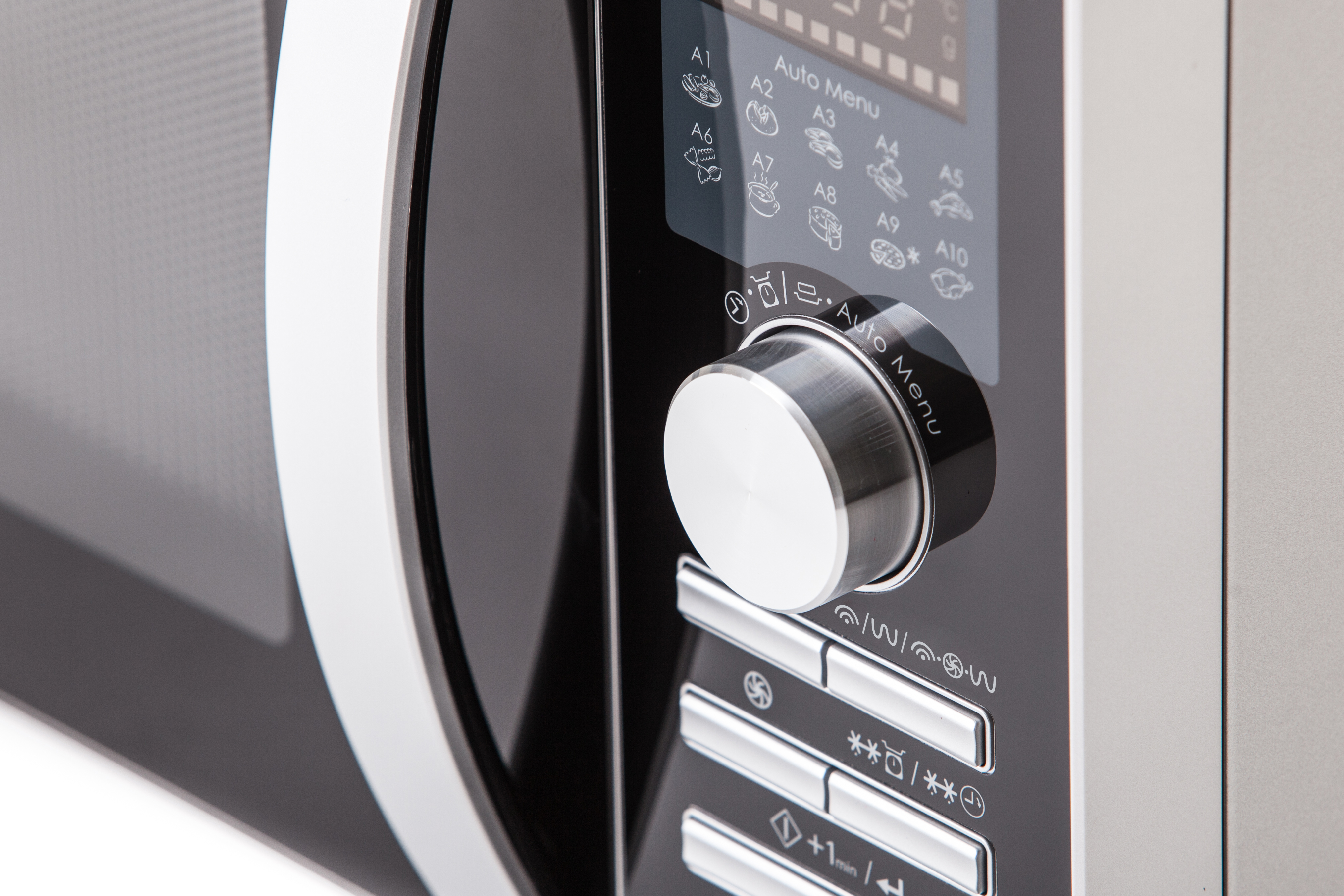 Close-up of a microwave control panel. Silver dial with 'Auto Menu'. Buttons below and digital display.