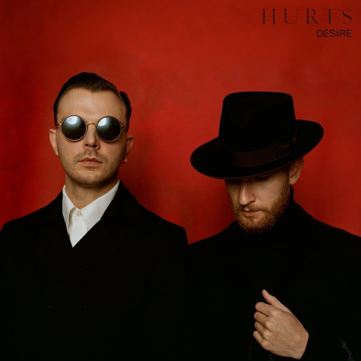 A Hurts - Desire album borítója. Két fekete ruhás férfi piros háttérrel.