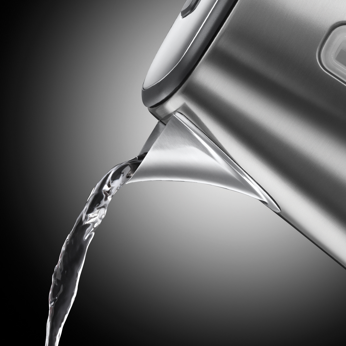 De l'eau coule d'une bouilloire argentée. Le fond est noir à gris.