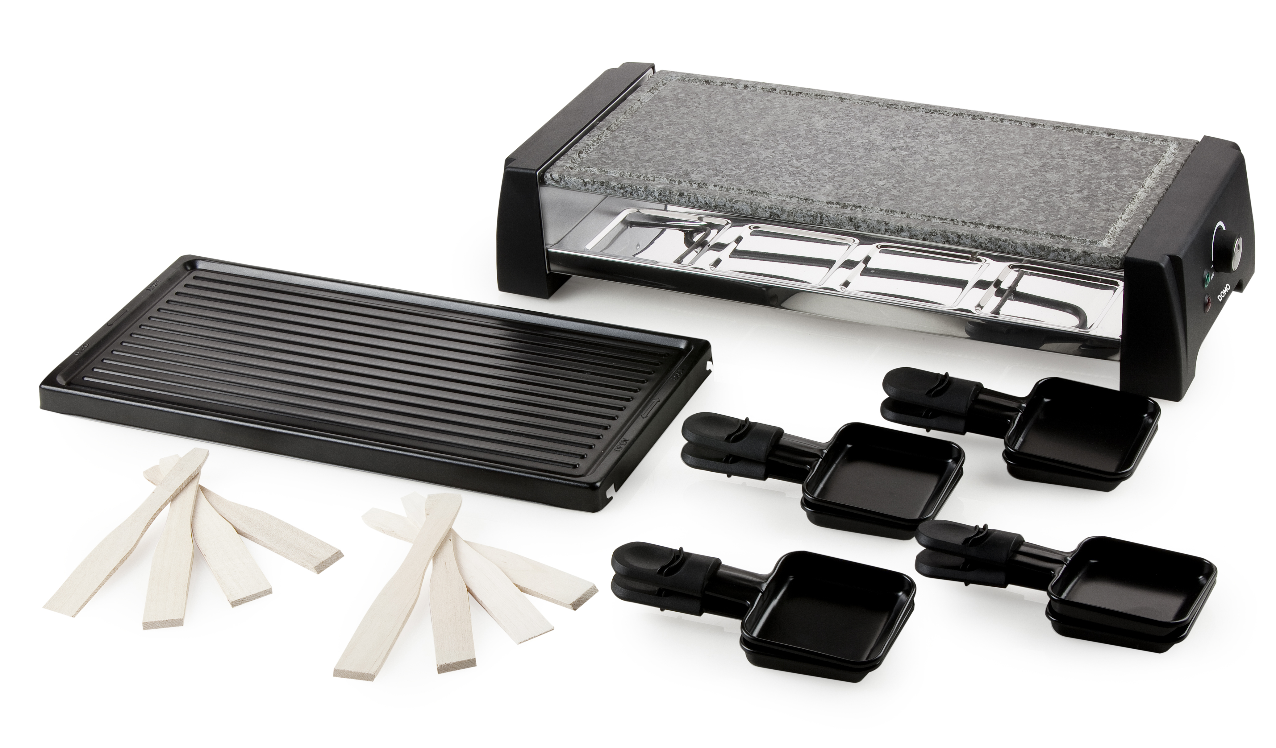 Raclette grill met stenen bovenkant, zwarte grillplaat, houten spatels en kaasbakjes. Witte achtergrond.