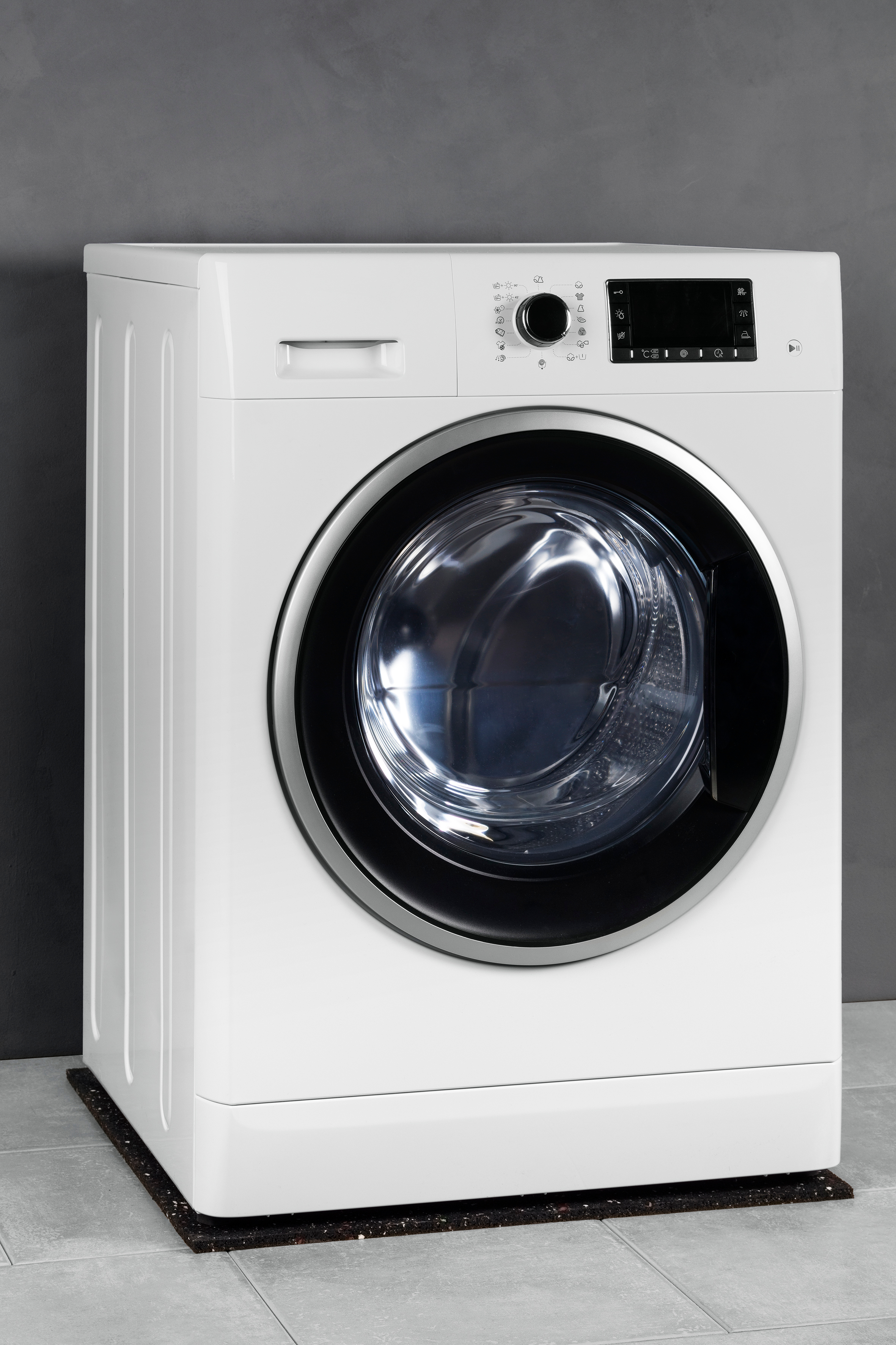 White washing machine on a grey tiled floor. Gray background.