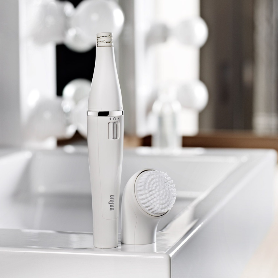 Brosse nettoyante visage Braun blanche et socle de chargement sur un lavabo blanc.
