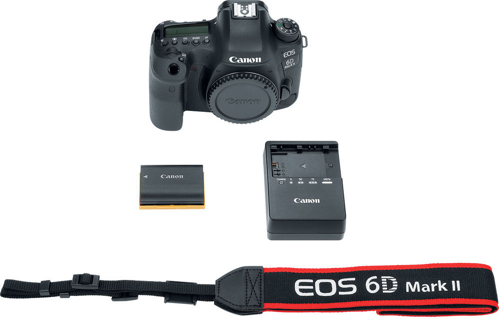 Egy Canon EOS 6D Mark II kamera, akkumulátor, töltő és szíj fehér felületen.