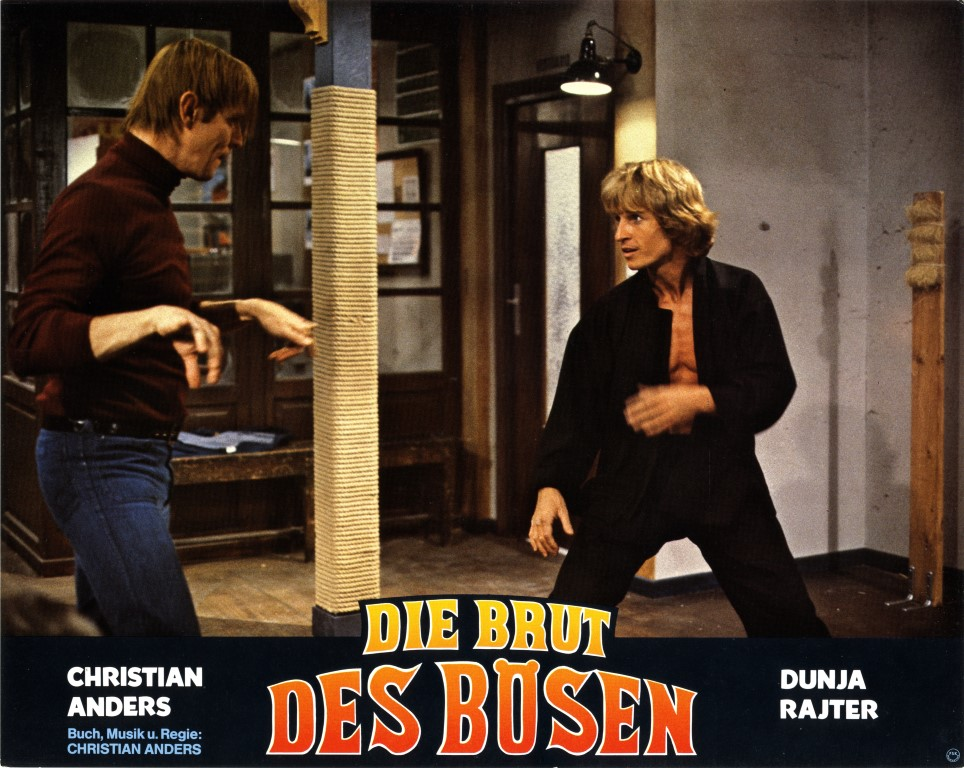 Filmposter von zwei Männern in einem Raum. Ein Mann in einem schwarzen Hemd und einer im Rollkragen. Titel unten.