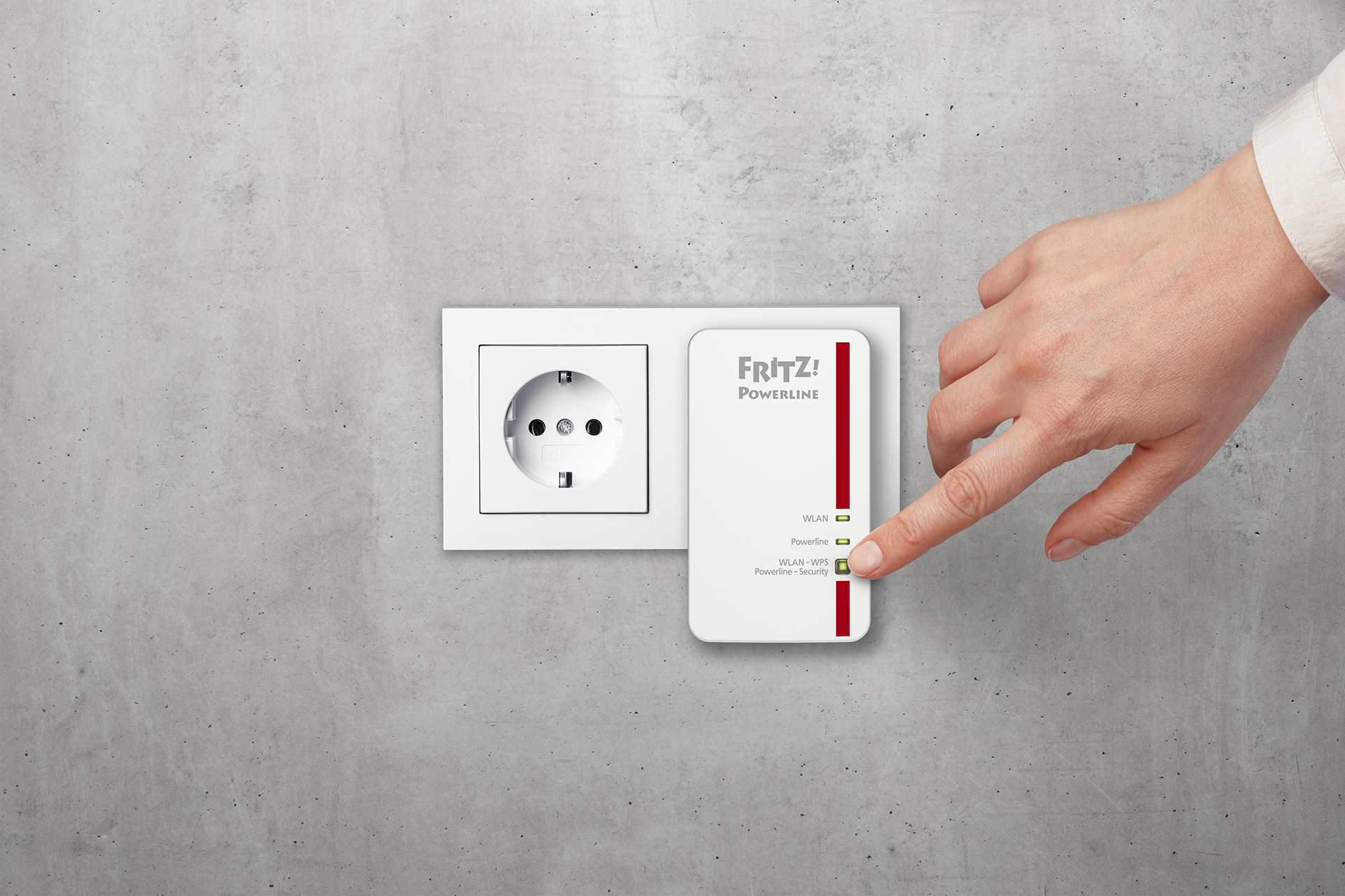 Eine Hand steckt einen weißen und roten Powerline-Adapter in eine Steckdose.
