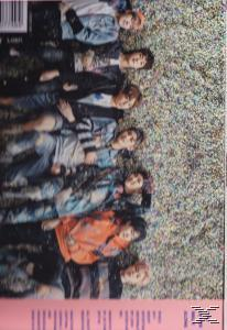 Groep mensen die op gras liggen, met een vage achtergrond. Kleding is casual, sommigen in spijkerjassen.