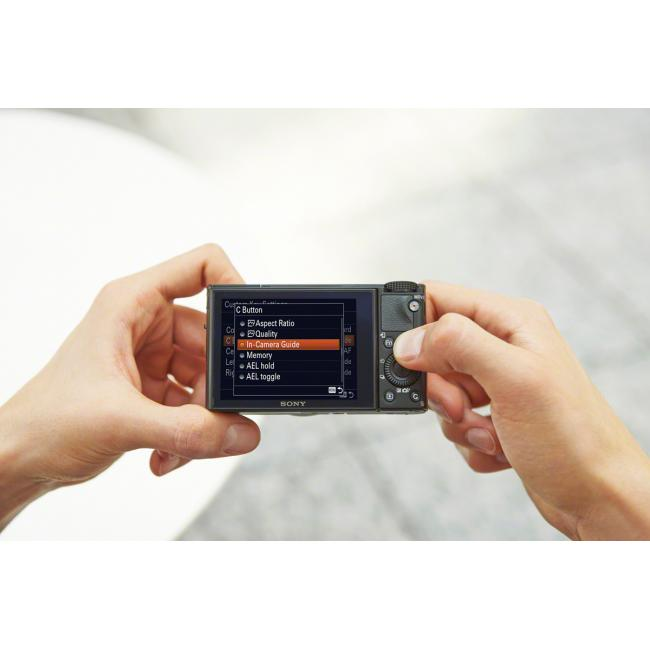 Une personne tenant un appareil photo Sony, utilisant le menu pour ajuster les paramètres.