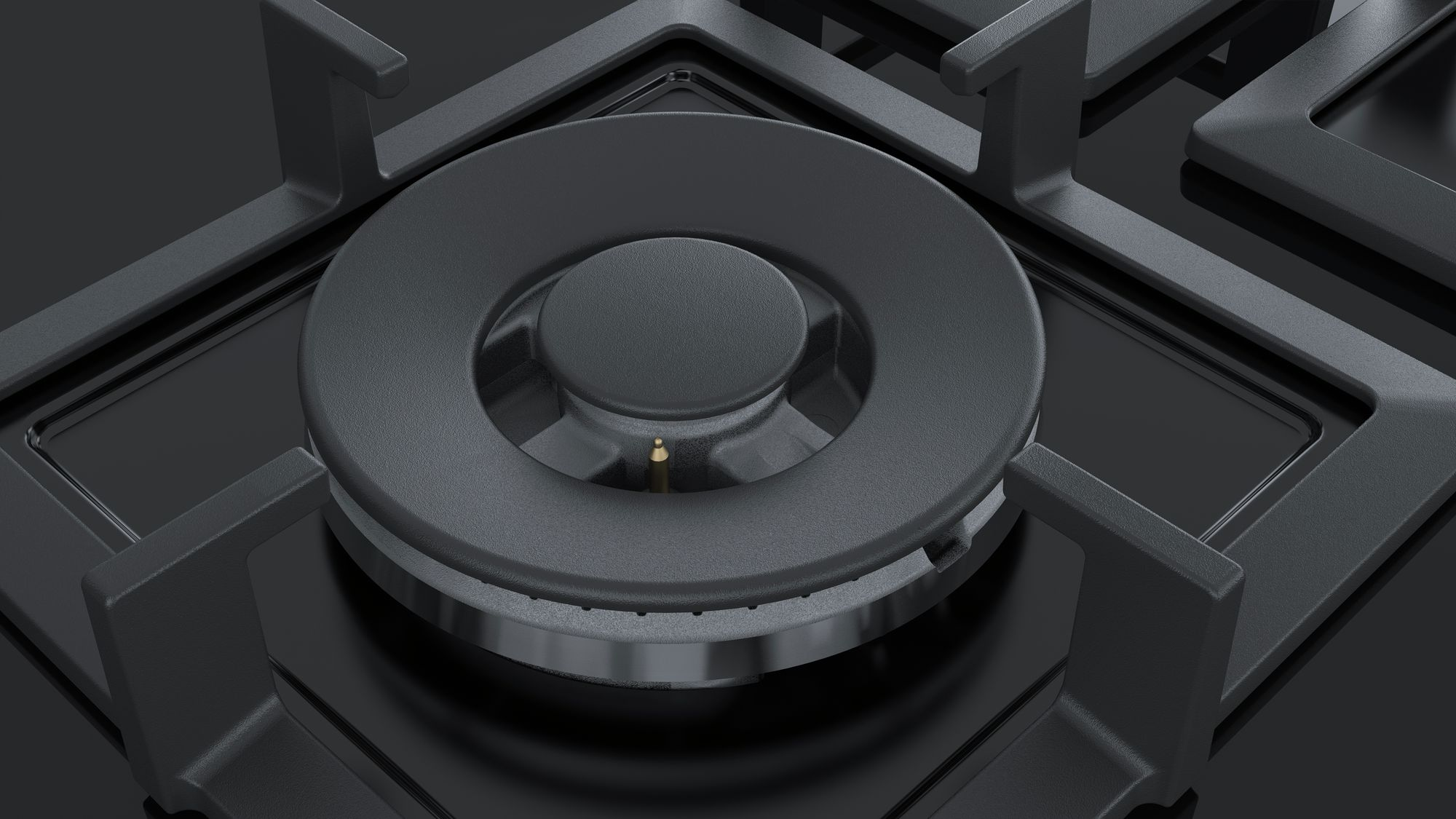 Close-up of a black gas stove burner and its surrounding area. The surface is black.