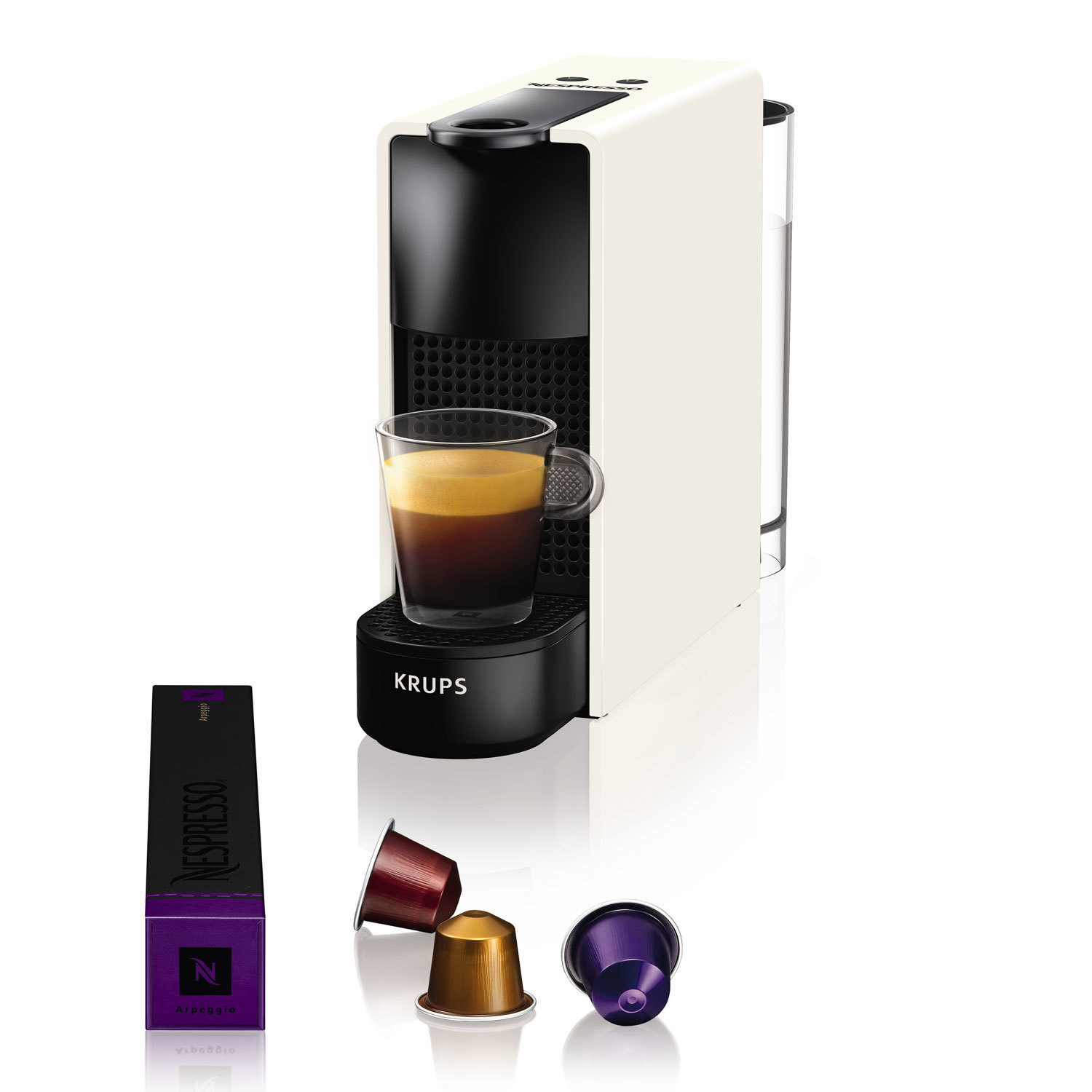 Weiße und schwarze Nespresso-Maschine, ein Glas Kaffee, Kapseln, auf weißer Oberfläche.