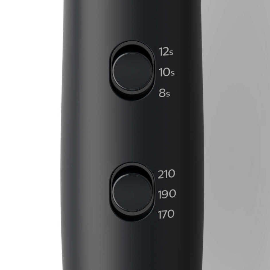 Close-up of a black hair dryer with two circular buttons and timer/heat settings.