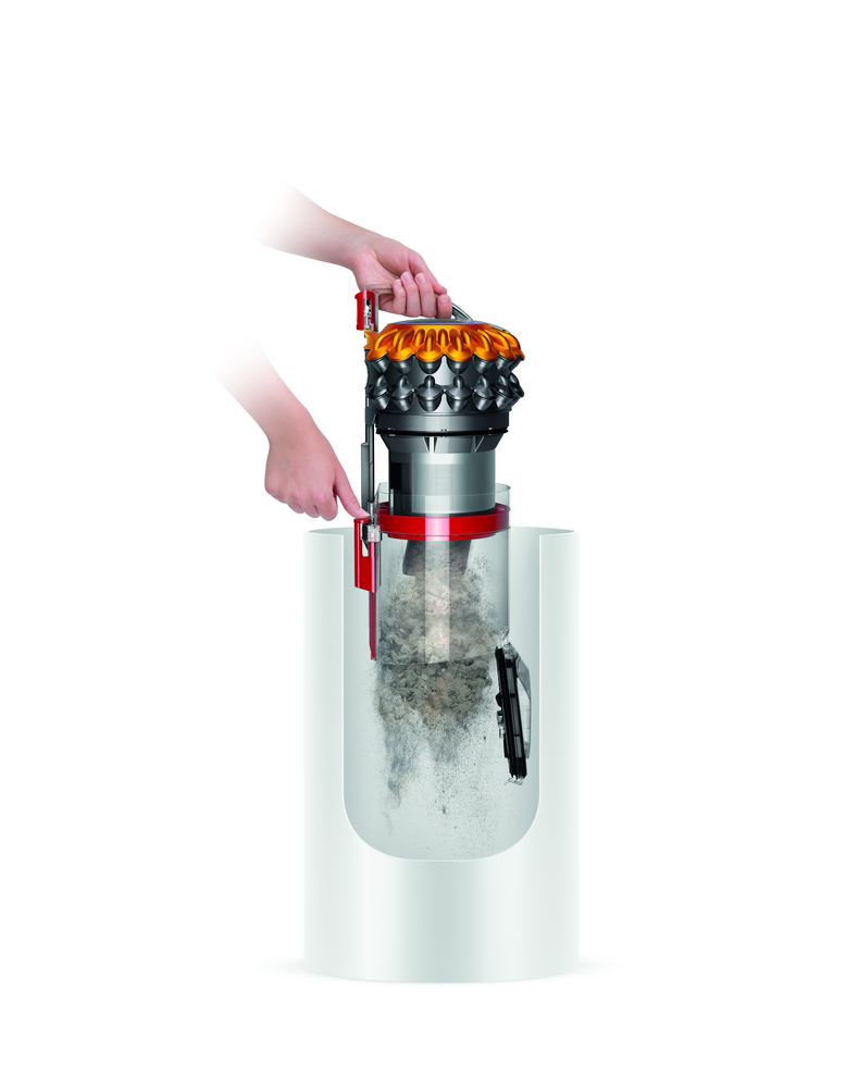 Aspirateur avec un récipient à saleté transparent. Une main tient la poignée.