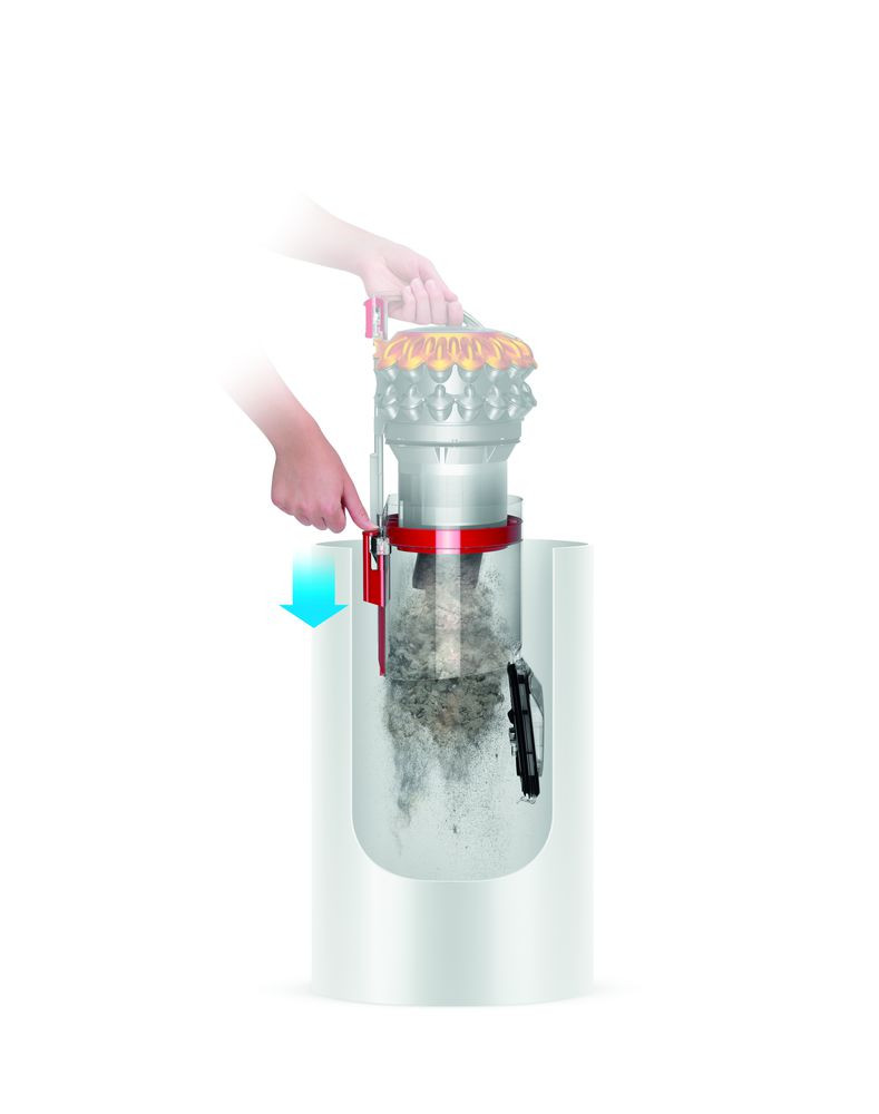 Coupe transversale d'aspirateur Dyson. Une main tire un levier. Poussière et débris visibles à l'intérieur du conteneur.