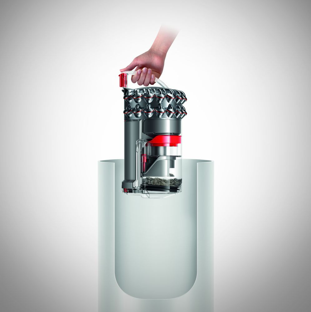 Vacuum cleaner cutaway, with hand holding the top part, showing the internal components.