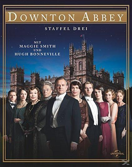 DVD-Cover von Downton Abbey, Staffel 3. Gruppenfoto der Darsteller vor einem Schloss bei Nacht.