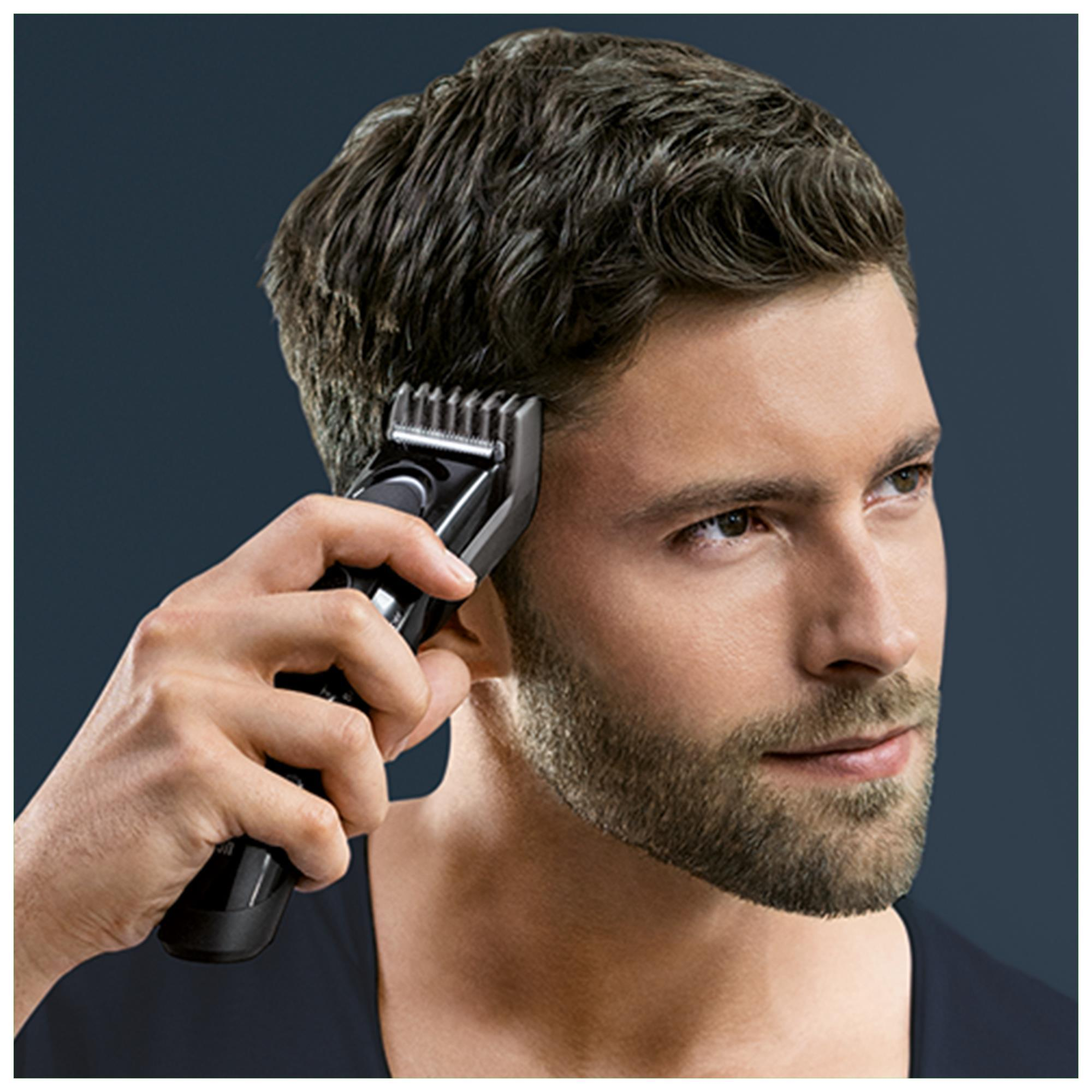 Mann benutzt einen Haarschneider an seinen Koteletten.