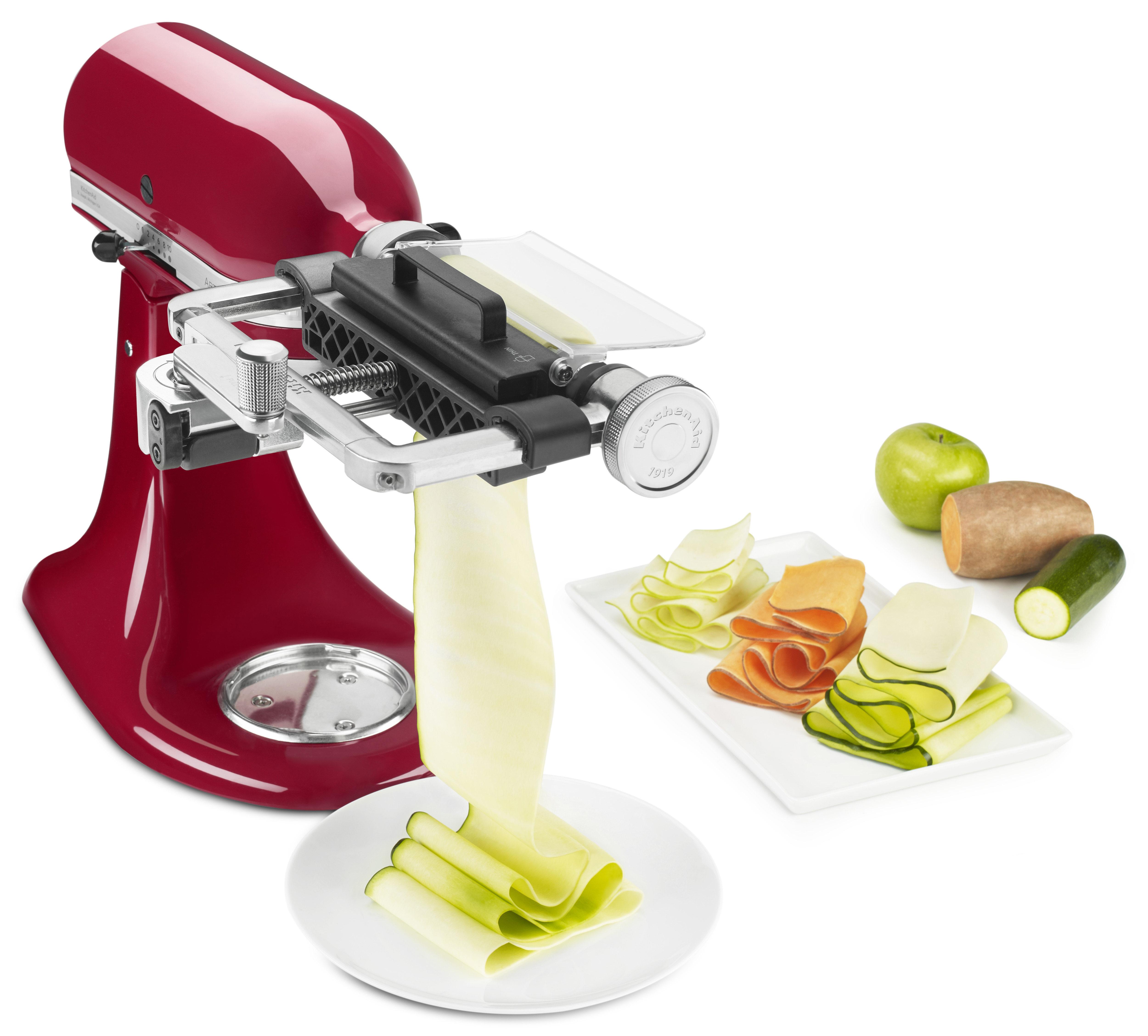 Rote KitchenAid mit Spiralschneider-Aufsatz, Gemüse und Zucchinischeiben.