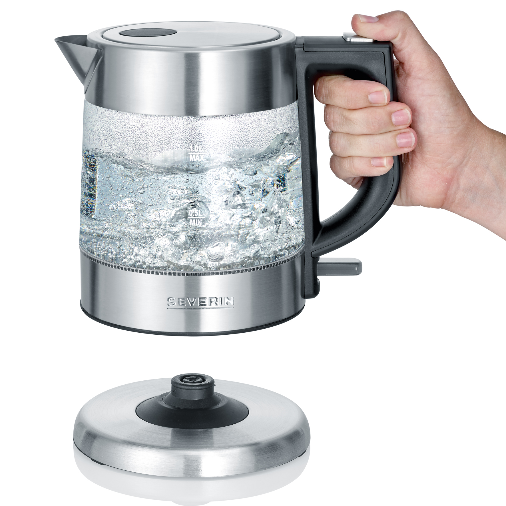 Eine Hand hält einen klaren elektrischen Glaskessel mit kochendem Wasser, auf seinem Sockel.