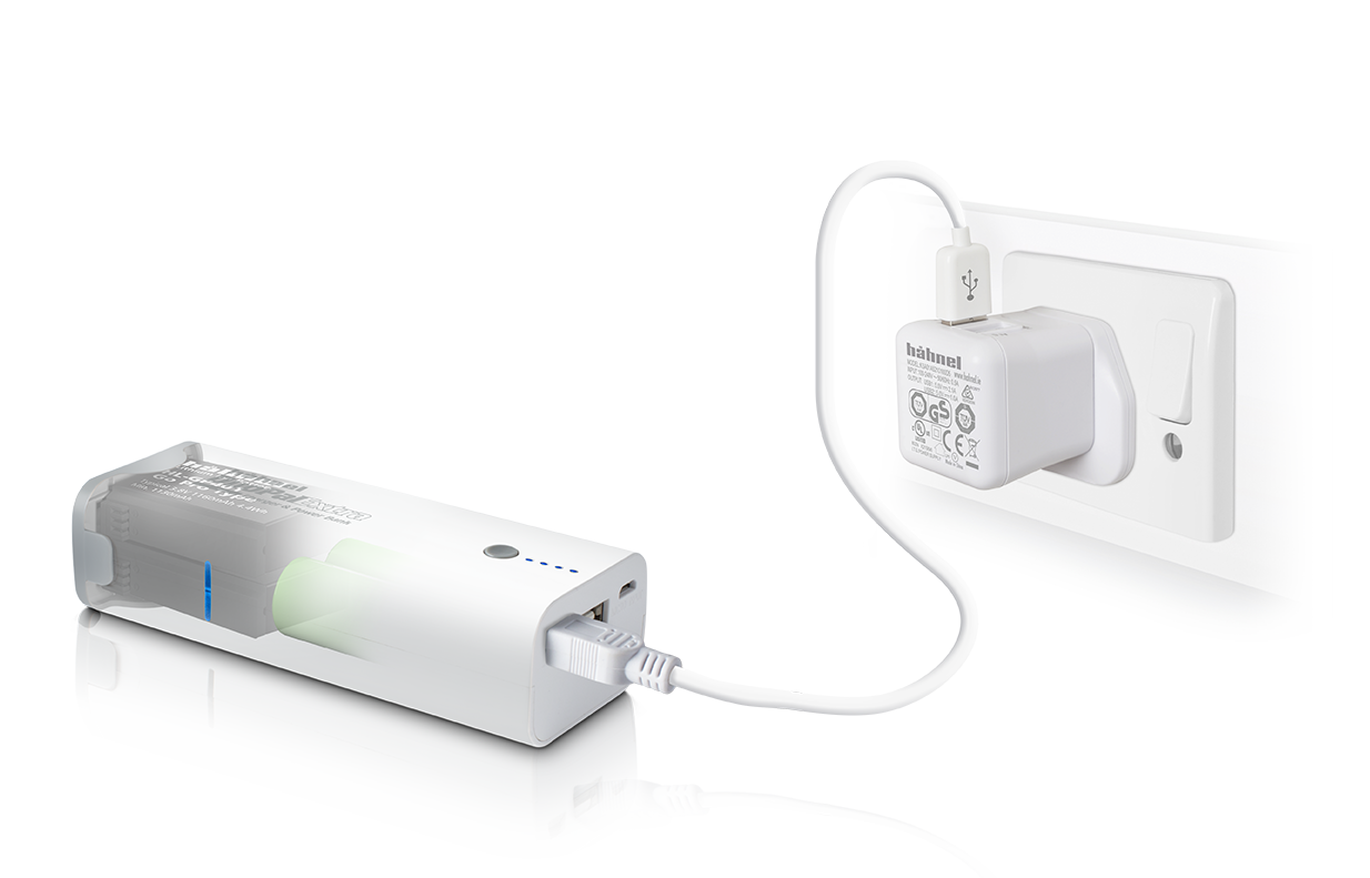 A white power bank is connected to a white power adapter plugged into a wall outlet.