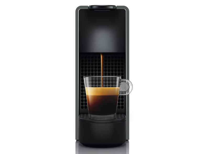 Espresszó gép kávét tölt üvegpohárba fekete háttéren.