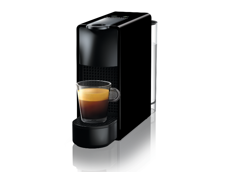 Fekete Nespresso kávéfőző átlátszó üvegpohár eszpresszóval. Fekete háttér.