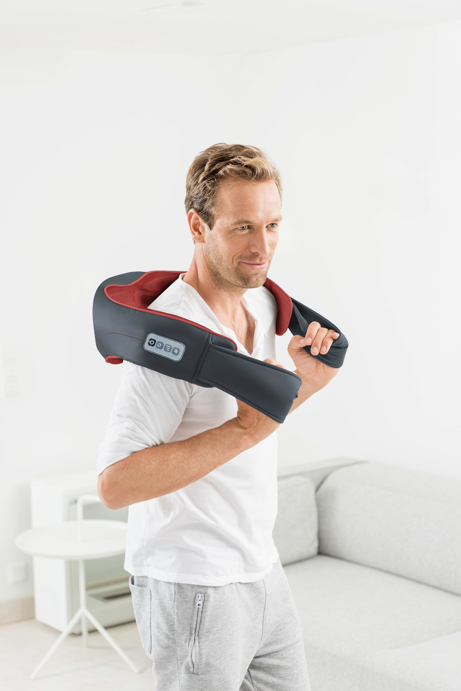 Mann mit Massagekragen. Zeigt ein Massagegerät um den Hals.