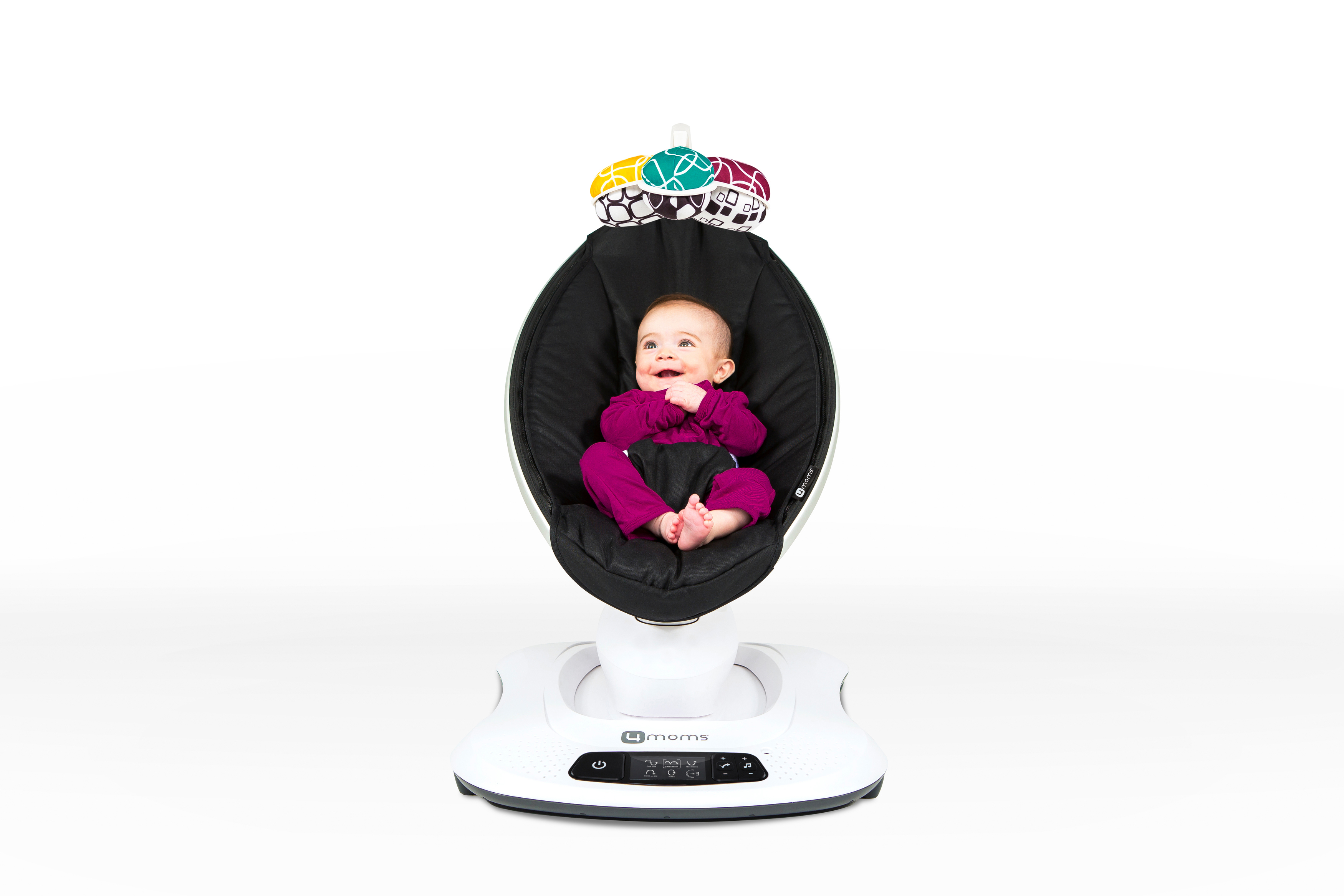Baby in einer Schaukel, schwarzer Sitz, weißer Sockel. Baby trägt einen lila Anzug. Weißer Hintergrund.