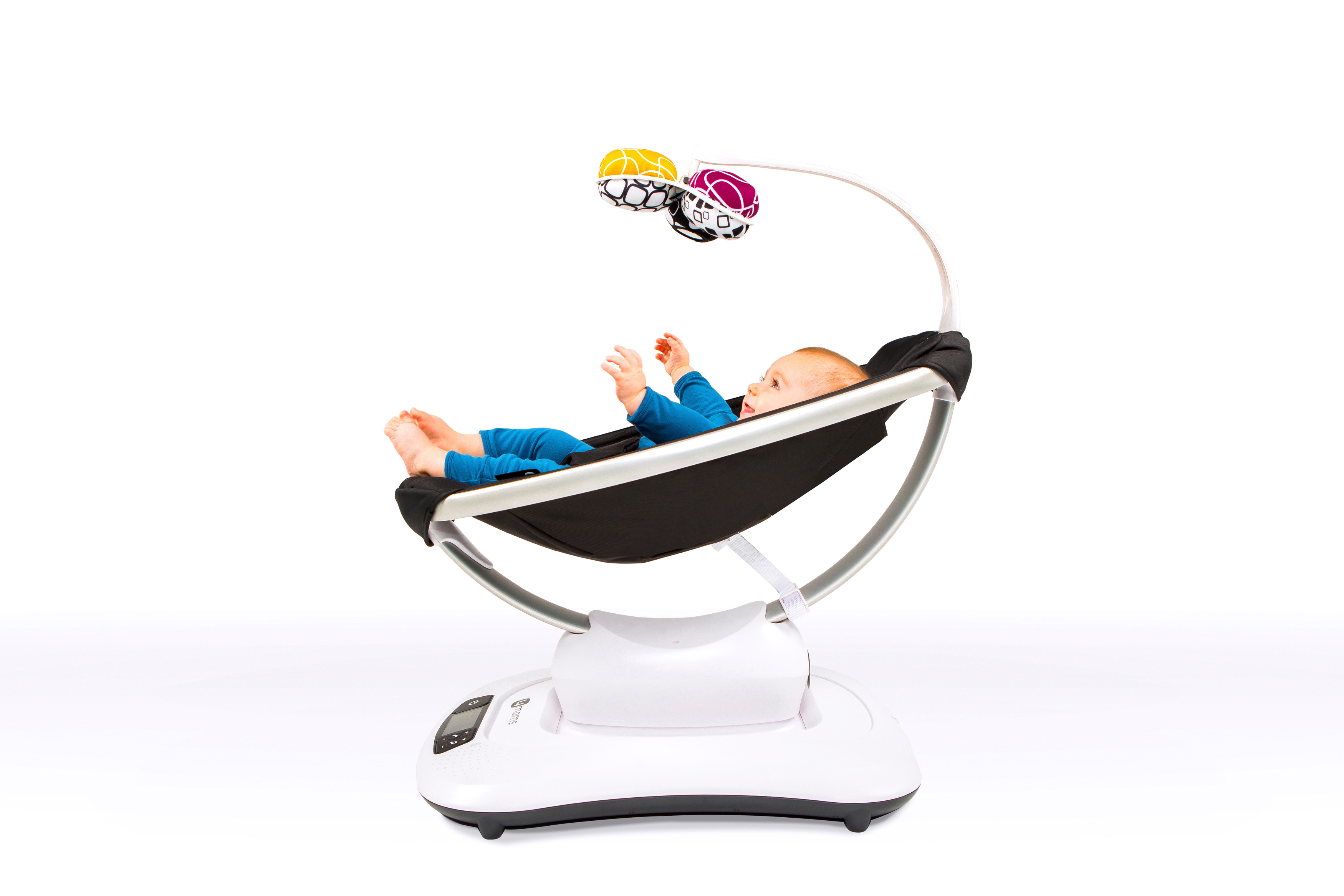 Baby in einer schwarz-weißen Schaukel mit hängendem Spielzeug auf weißem Grund.