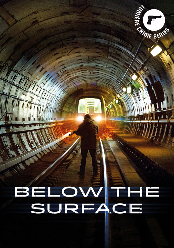 Homme debout dans un tunnel sombre avec des voies ferrées. Le tunnel mène à des lumières vives au bout.