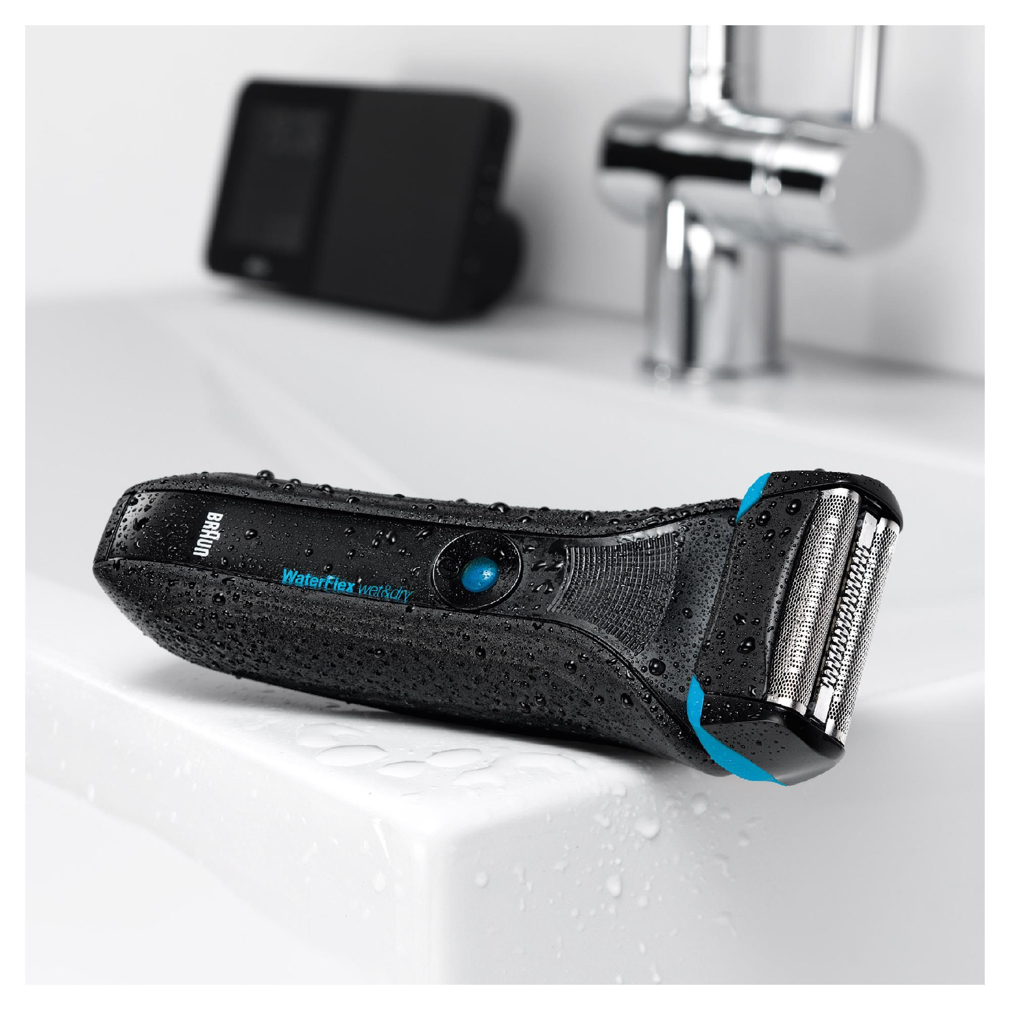 Schwarzer und blauer Elektrorasierer auf einem weißen Waschbecken, umgeben von Wasser.