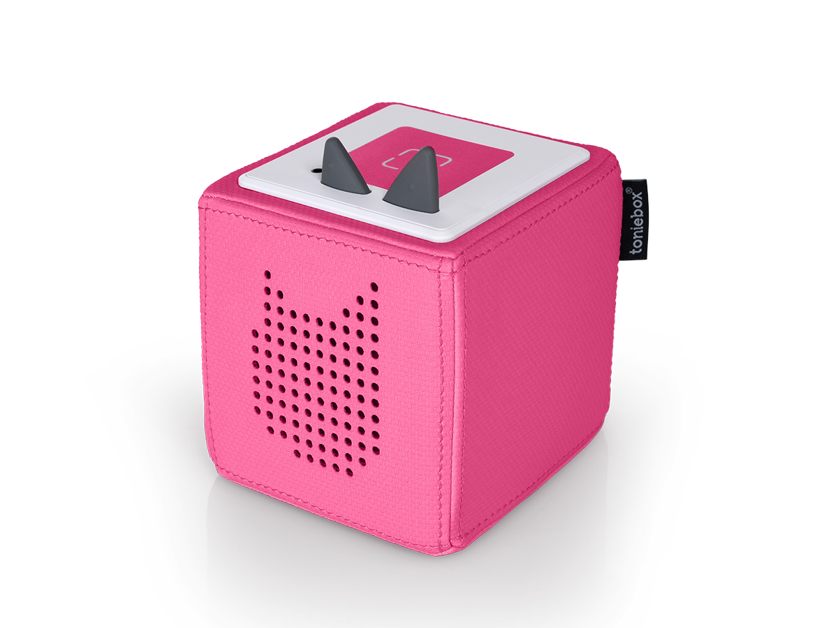 Ein rosa Toniebox-Würfel mit grauen Ohren oben, einem weißen Deckel mit pinkfarbenem Knopf und einem Lautsprecher in Katzenform.