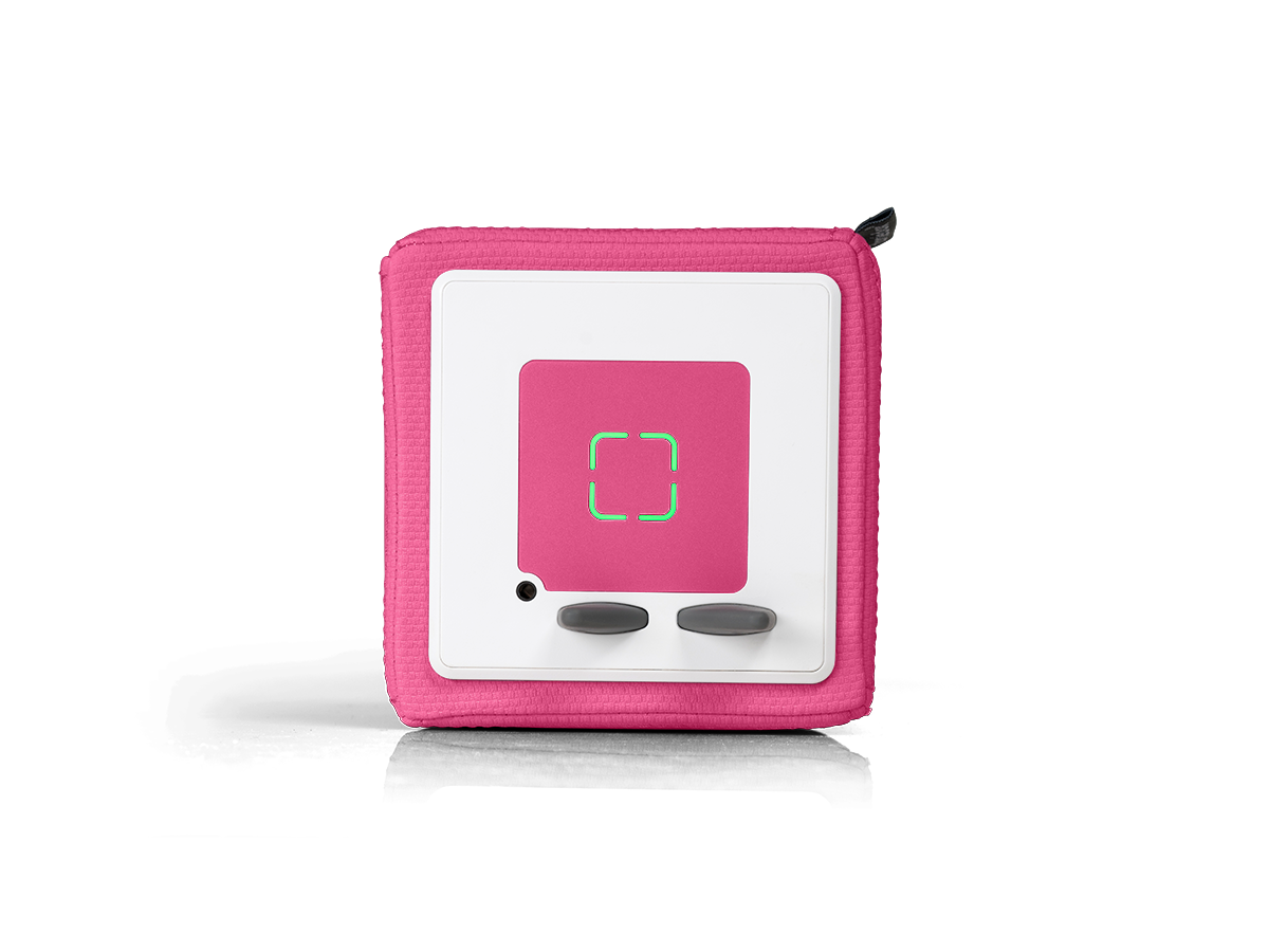 Ein rosa-weißes Gerät mit einem rosa Mittelquadrat. In der Mitte befindet sich eine grüne quadratische Umrandung. Darunter zwei graue Knöpfe.