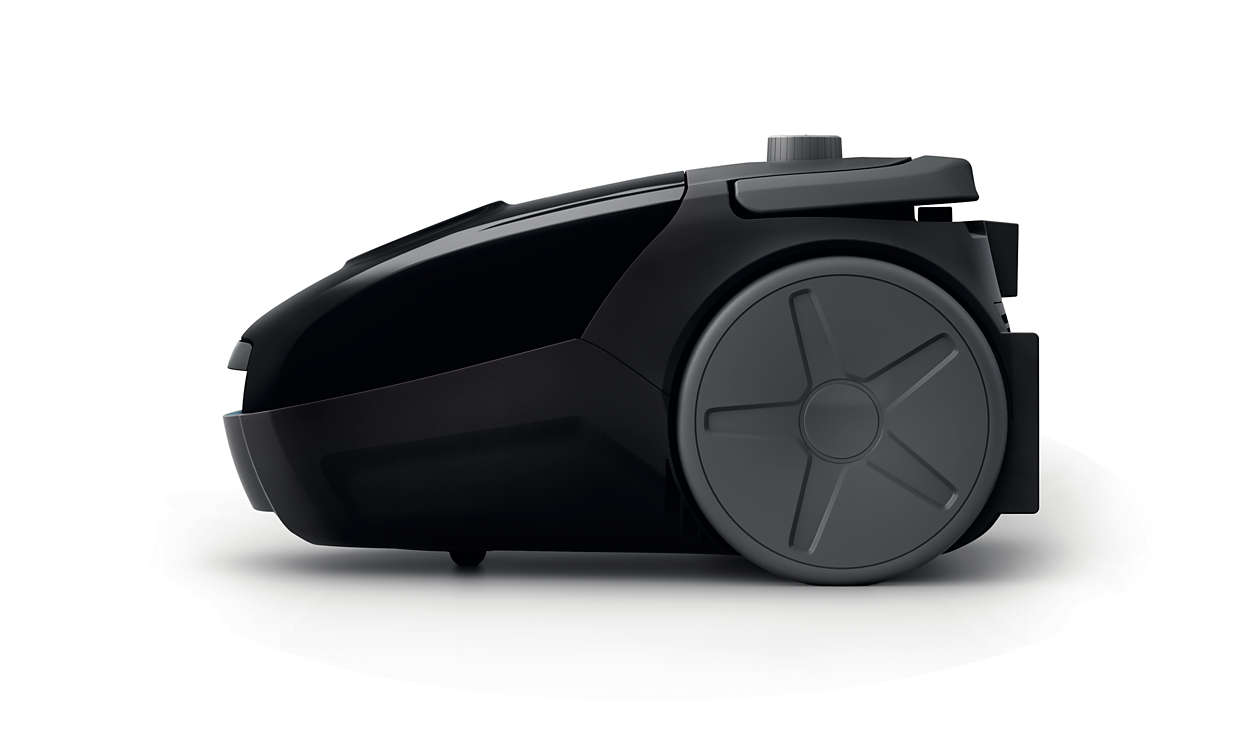 Black vacuum cleaner, side view. It has a rounded front and a large wheel.