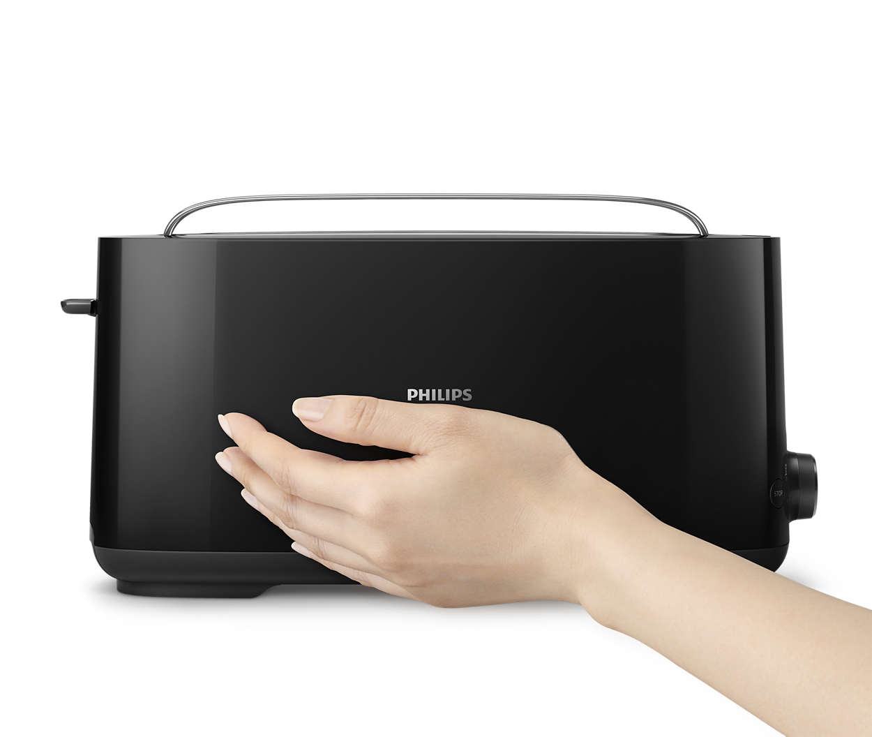 A hand presses a button on a black Philips toaster. White background.