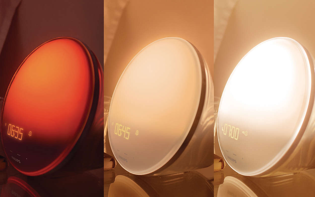 Lampe de réveil Philips montrant trois étapes de l'effet lever de soleil. La lumière passe du rouge au blanc.