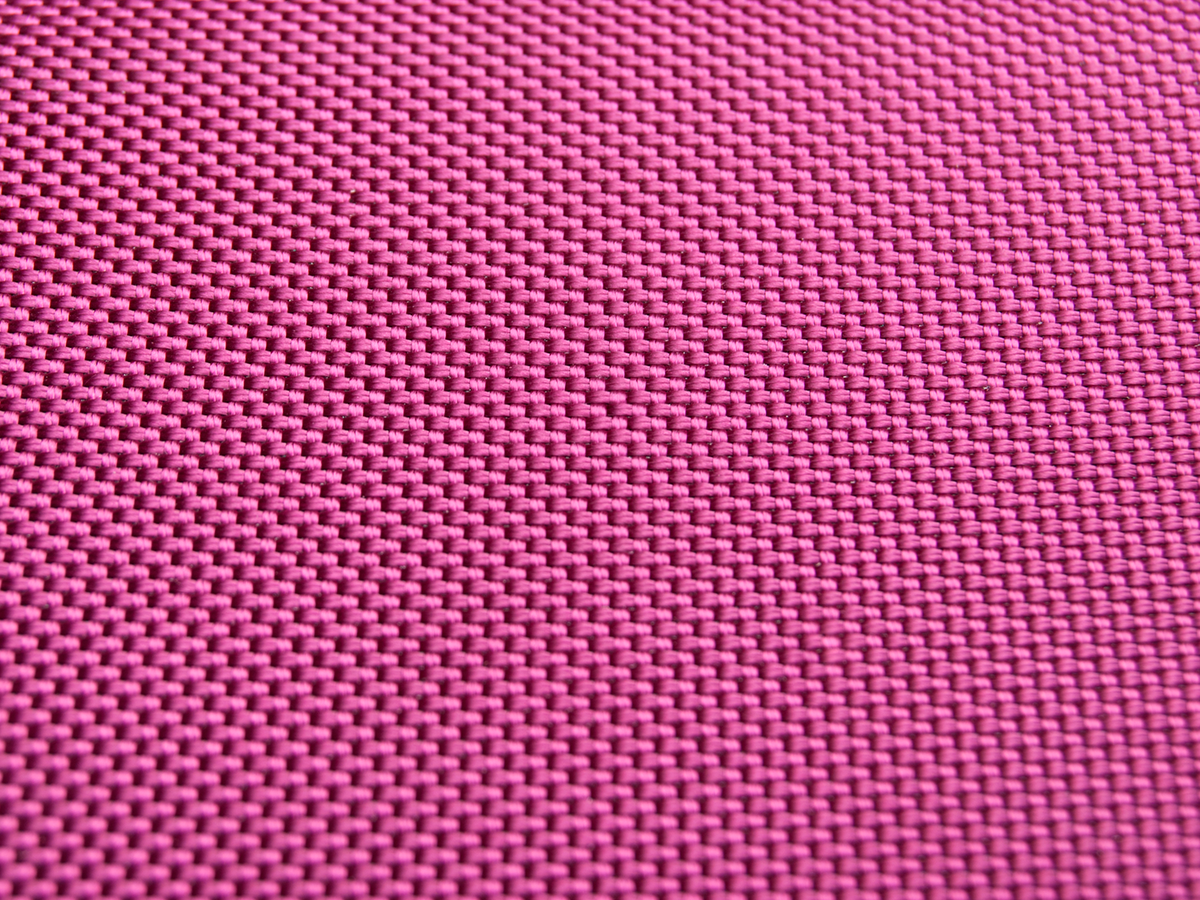 Nahaufnahme eines rosa Textils mit gewebtem Muster. Die Textur ist detailliert.