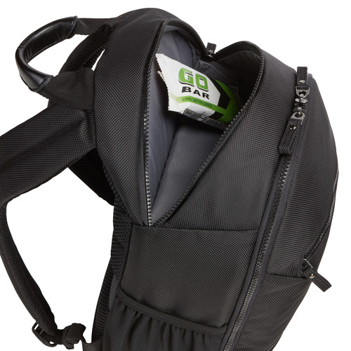 A black backpack with an open pocket holding a GO Bar, a snack.