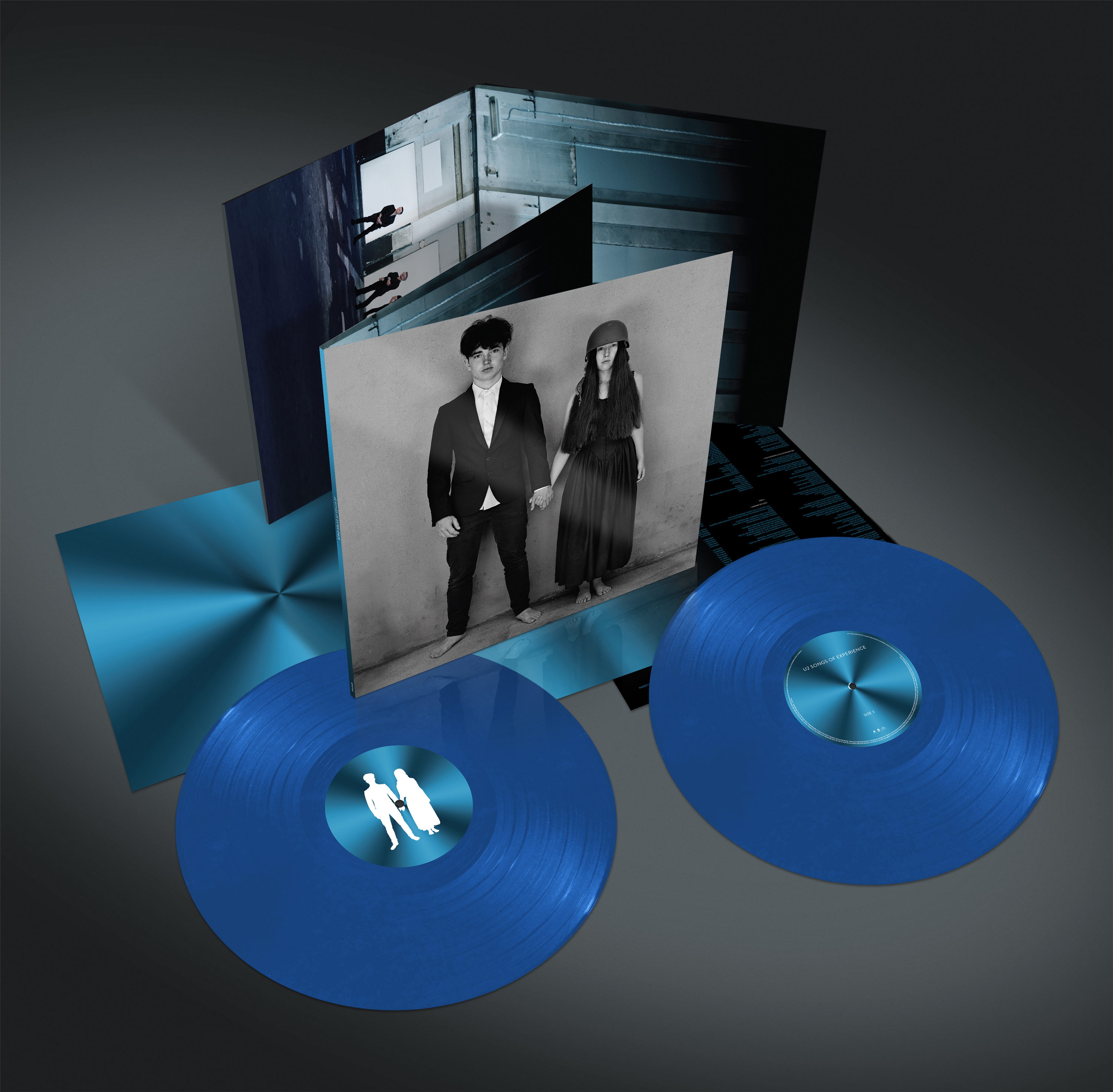 Albumcover mit zwei blauen Vinylplatten, einem Schwarz-Weiß-Foto und einem Spiegelhintergrund.