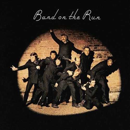 Album borító, fekete háttér, sötét öltönyös férfiak reflektorfényben, 'Band on the Run' felirat.