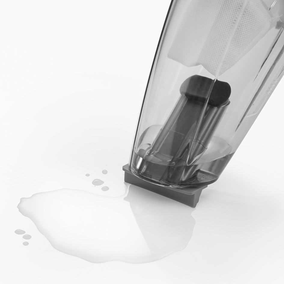 Une partie d'aspirateur avec une éclaboussure d'eau sur une surface blanche. La partie est transparente.