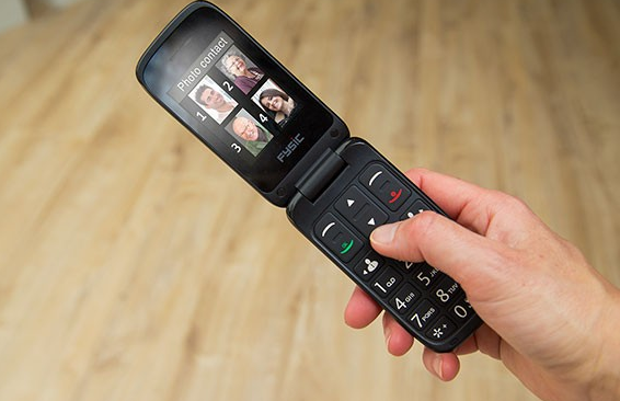 Een klaptelefoon met een scherm met vier foto's van mensen. Een hand houdt de telefoon vast.