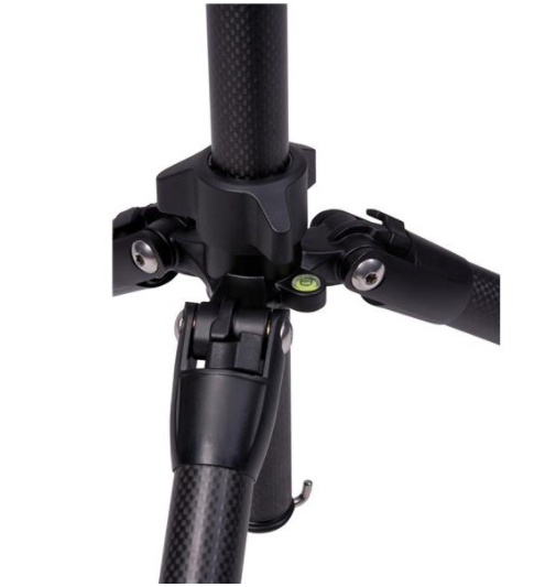 Close-up of a black tripod base. It has three legs connected to a central column. A small level is visible. White background.