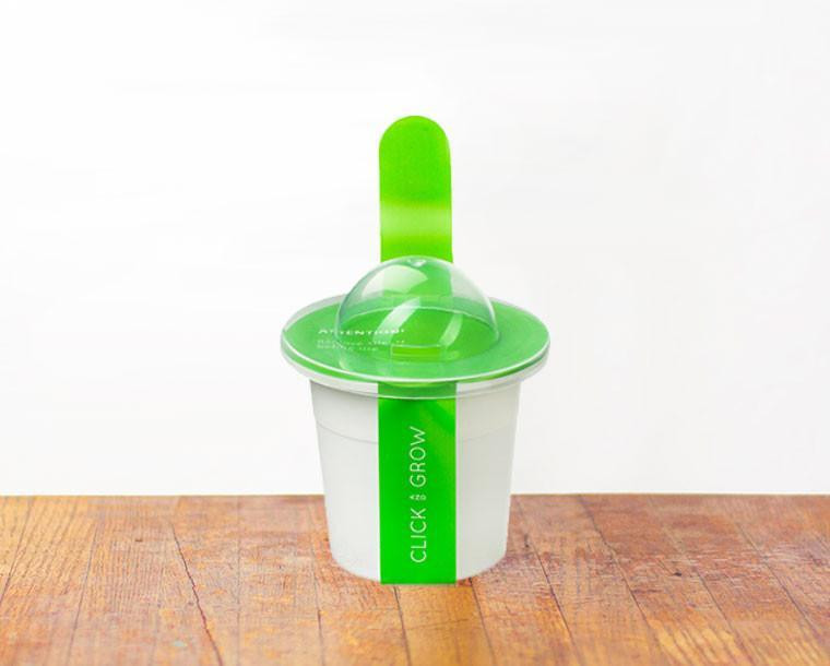 Een witte en groene click and grow plantenpot. Groen deksel en stok.
